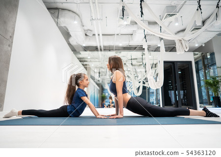 Young adult mom and little daughter together on aerobics 54363120