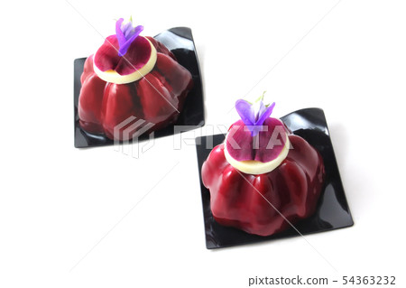 Two red fruit desserts with edible purple pea flower 54363232
