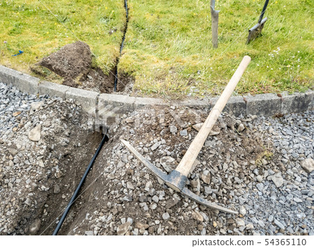 Engineers digging a new fibre cable into the ground Engineers digging a new fibre cable into the ground 54365110
