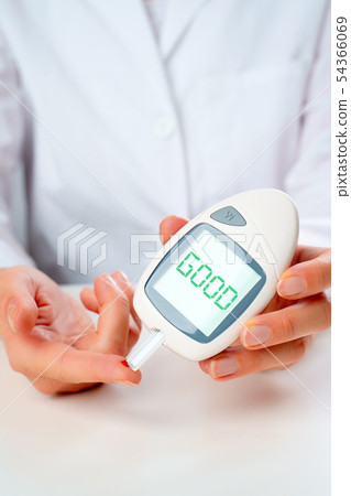 Photo of hand man with glucometer with words good in studio 54366069