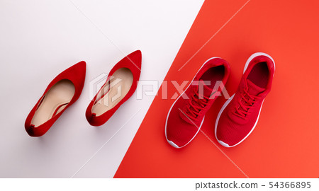 A studio shot of pair of running vs high heel shoes on color background. Flat lay. A studio shot of pair of running vs high heel shoes on color background. Flat lay. 54366895