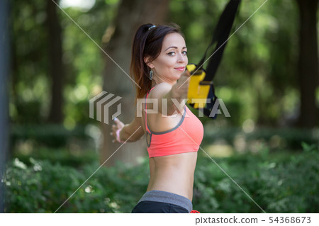 Pretty young girl doing sports on the playground with TRX . Healthy lifestyle, training on trx 54368673