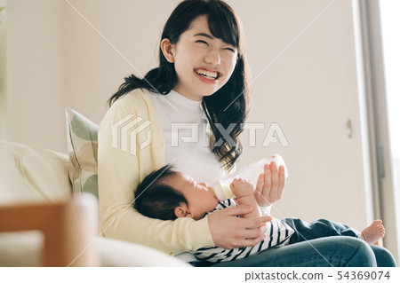 Mother making baby drink milk with baby bottle 54369074