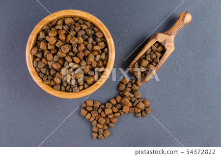 dog food in a bowl and snack like bone on black background, top view 54372822