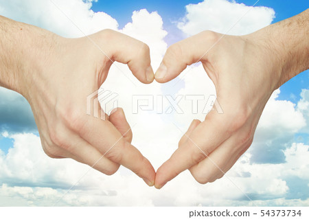 Hands make heart shape against blue sky background 54373734
