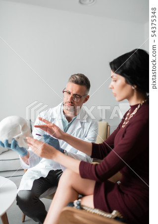 Plastic surgeon consulting woman before making rhinoplasty Plastic surgeon consulting woman before making rhinoplasty 54375348