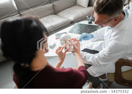 Client of plastic surgeon asking questions about nasal surgery Client of plastic surgeon asking questions about nasal surgery 54375352