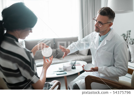 Woman looking at breast implants before having surgery Woman looking at breast implants before having surgery 54375796