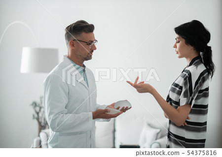 Dark-haired woman asking questions about implants for breast Dark-haired woman asking questions about implants for breast 54375816