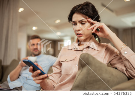 Dark-haired woman feeling worried before meeting plastic surgeon Dark-haired woman feeling worried before meeting plastic surgeon 54376355
