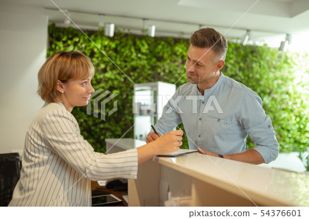 Administrator wearing striped jacket talking to constant client 54376601