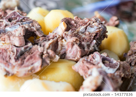 Boiled lamb meat and whole potatoes close up 54377836