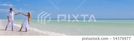 Happy Young Couple Dancing Holding Hands on Beach 54378977