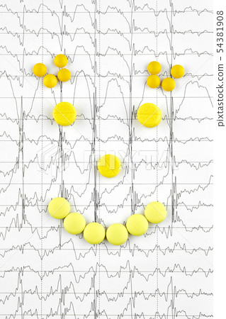 Face made of yellow pills on EKG graph. Medicine Face made of yellow pills on EKG graph. Medicine 54381908