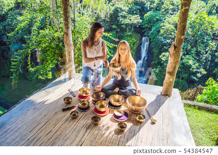 Nepal Buddha copper singing bowl at spa salon. Young beautiful woman doing massage therapy singing 54384547