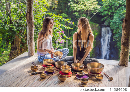 Nepal Buddha copper singing bowl at spa salon. Young beautiful woman doing massage therapy singing 54384608