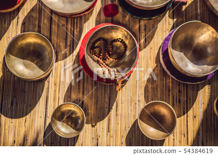 Tibetan singing bowls on a straw mat Tibetan singing bowls on a straw mat 54384619