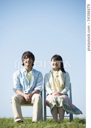 Couple sitting on a chair in the meadow 54386879