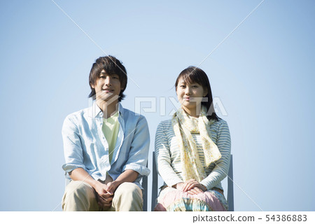 A couple sitting in a chair 54386883