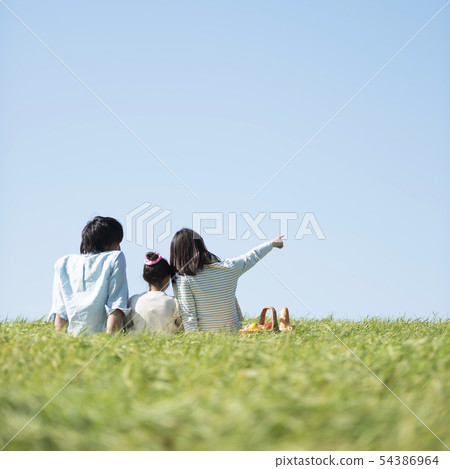Behind the family doing a picnic in the meadow Behind the family doing a picnic in the meadow 54386964