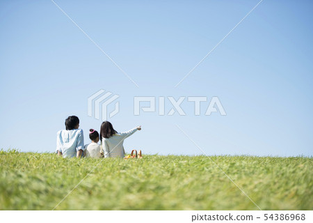 Behind the family doing a picnic in the meadow 54386968