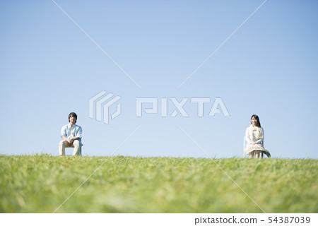 夫婦坐一把椅子在草甸 54387039