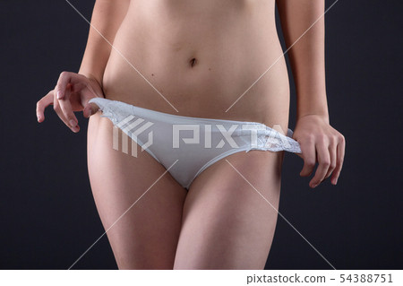 Hands take off shorts with a tanned female body 54388751