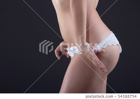 Hands take off shorts with a tanned female body 54388754
