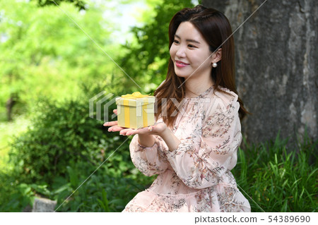 接受禮物的愉快的亞裔韓國少婦 接受禮物的愉快的亞裔韓國少婦 54389690
