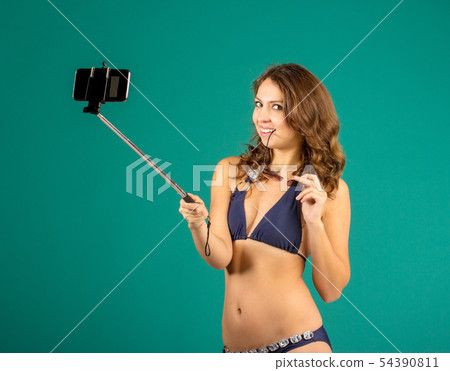 Woman in swimsuits taking a selfie. 54390811