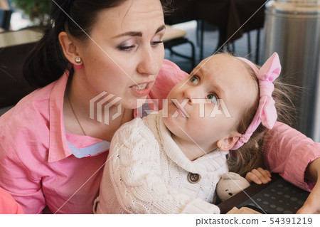 Mom with children in the cafe read the menu Mom with children in the cafe read the menu 54391219