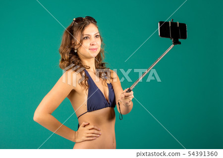 Woman in swimsuits taking a selfie. 54391360