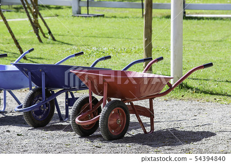 wheelbarrow carts colorful material on the floor. 54394840