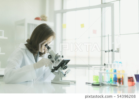 Asian scientist look throgh microscope.. 54396208