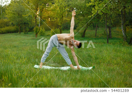 Man practicing yoga in the park Man practicing yoga in the park 54401289