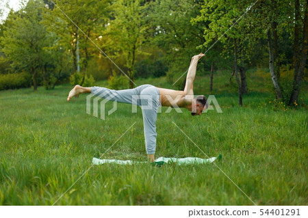 Young man practicing yoga in the garden  54401291