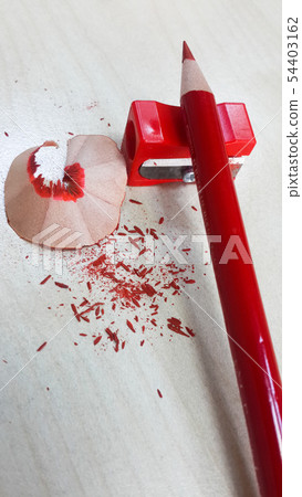 Red pencil and sharpener, isolated on wood backgro 54403162