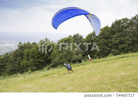 Paraglider taking off from the edge of the Paraglider taking off from the edge of the 54405727