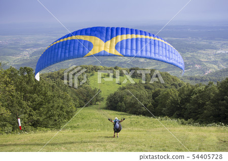 Paraglider taking off from the edge of the Paraglider taking off from the edge of the 54405728