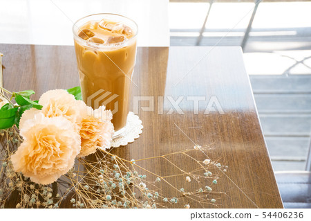 在玻璃桌上的拿鐵咖啡與玻璃和花 在玻璃桌上的拿鐵咖啡與玻璃和花 54406236