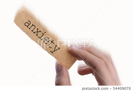 Anxiety wording on blank torn notepaper in hand 54409078