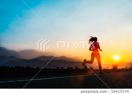 Young woman enjoys running on road. 54415574
