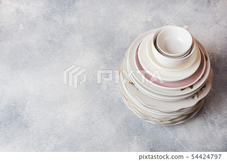 Stack of empty clean plates on a gray table  54424797
