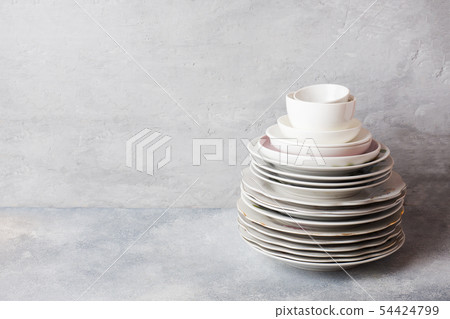 Stack of empty clean plates on a gray table  54424799