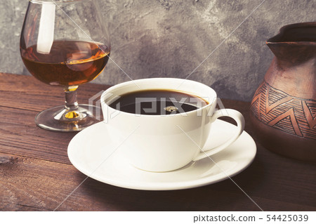 Coffee in white cup with cognac and clay cezve on 54425039