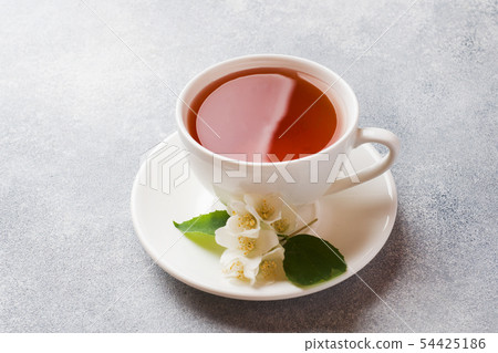 Cup of tea with Jasmine flowers on a gray table 54425186