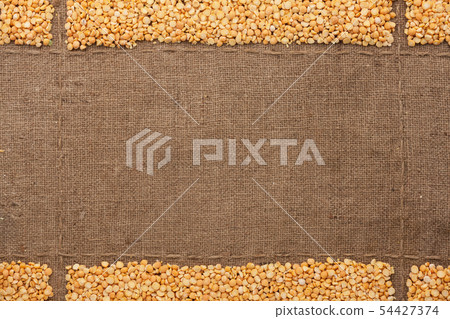 Dry peas grains on burlap, with place for text. Dry peas grains on burlap, with place for text. 54427374
