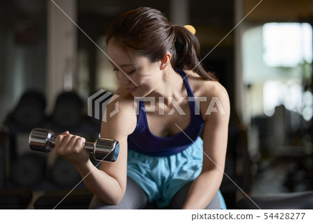 Gym woman dumbbells muscle workout 54428277