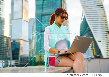 Portrait of business woman sitting with laptop and cup of coffee 54428708