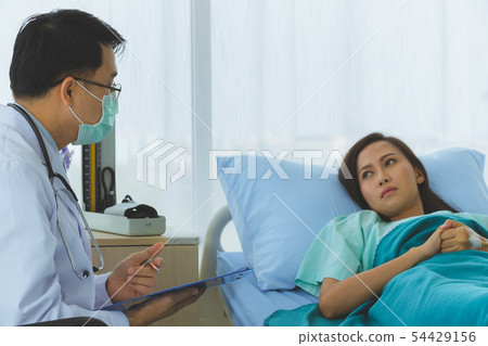 Doctor took the pulse of the female patient. 54429156